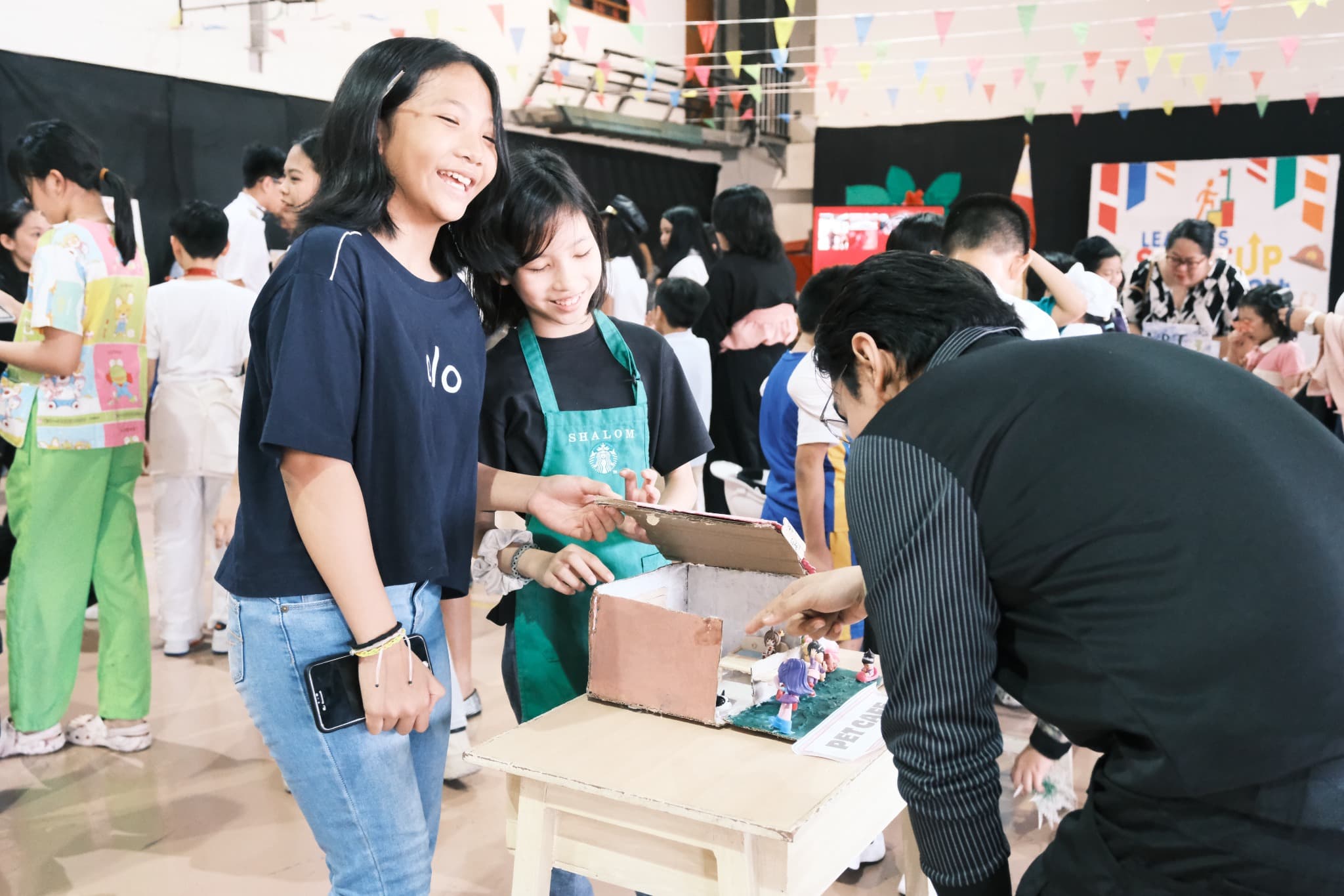 Students at Leaders sharing a creative project during a school activity.